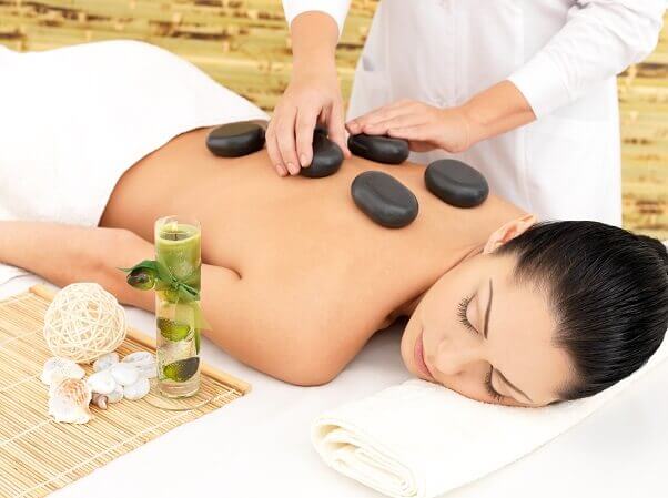Woman having hot stone spa massage