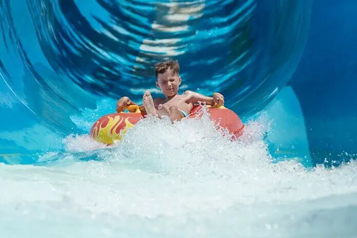 Boy having fun on the water slide on floater